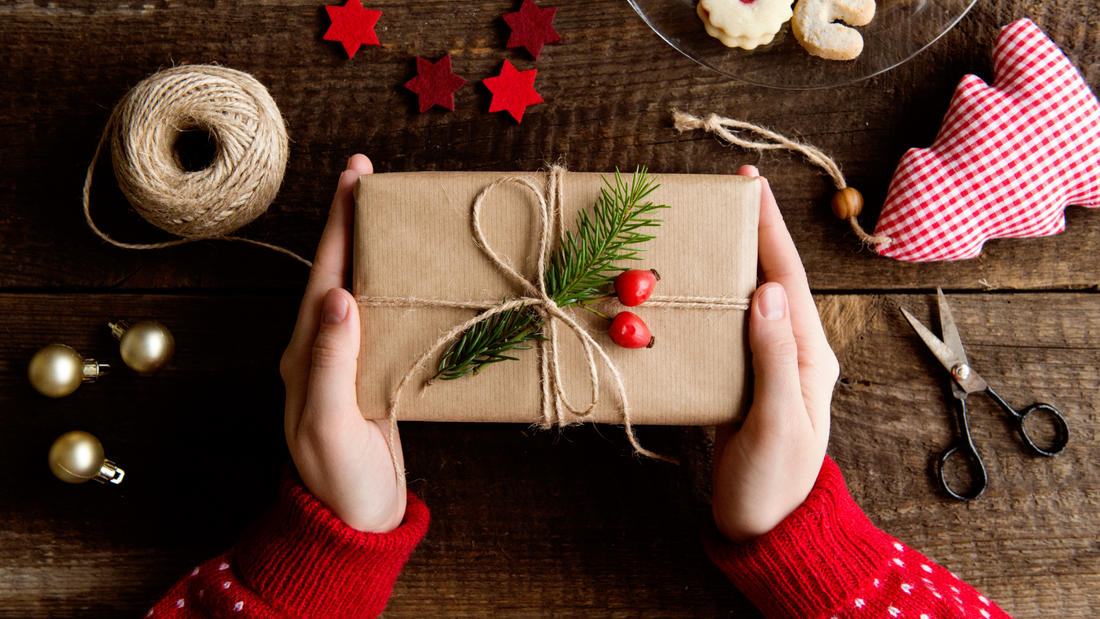 Picture of hands wrapping Christmas gift with berries