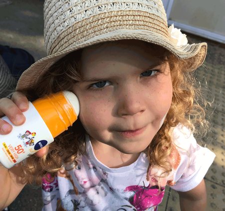 Picture of a young girl applying Nivea roll on sun cream to face