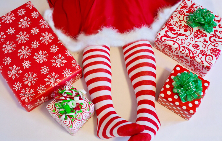 Picture of Mrs Claus legs in red striped tights surrounded by presents 